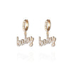 Pair of small pierced huggie hoop crystal earrings with a baby word pendant 