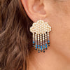 Right ear of a person wearing statement, raincloud shaped earring with pearl and crystal design