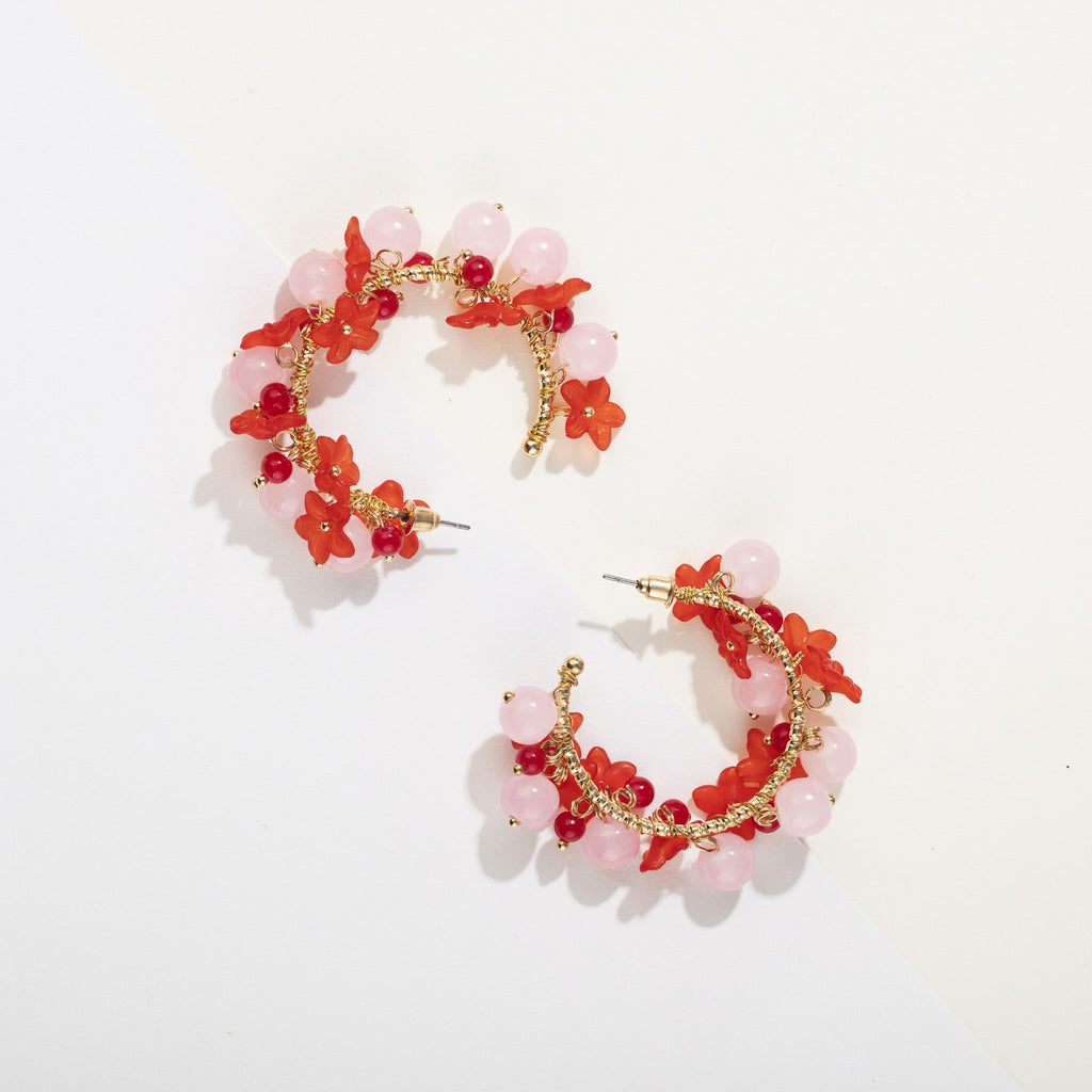 Pair of golden hoop earrings with red and pink beaded flower design