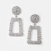 Pair of statement pierced earrings in textured silver effect with a large round stud and rectangular pendant